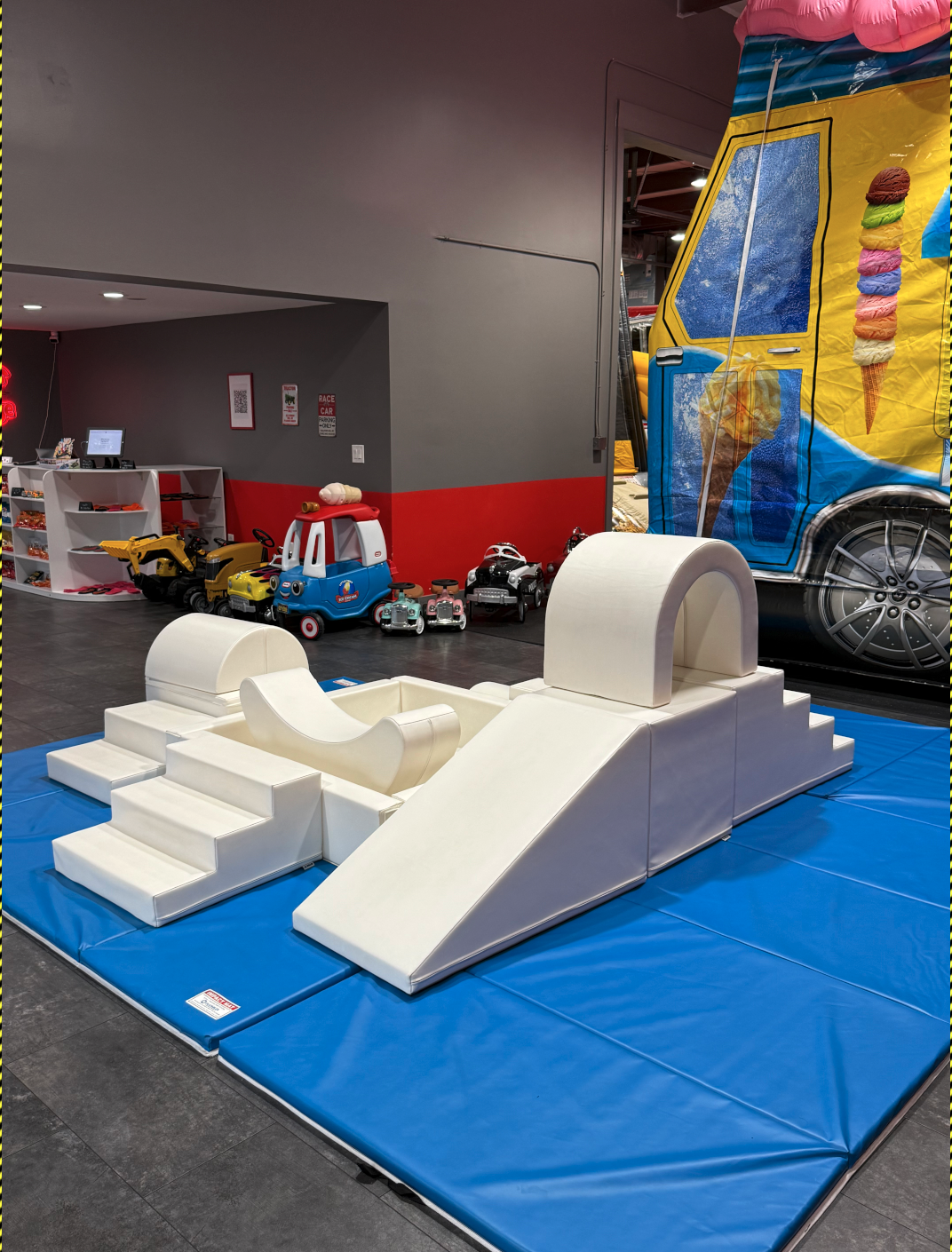 Toddler soft-play climber with ride-on cars